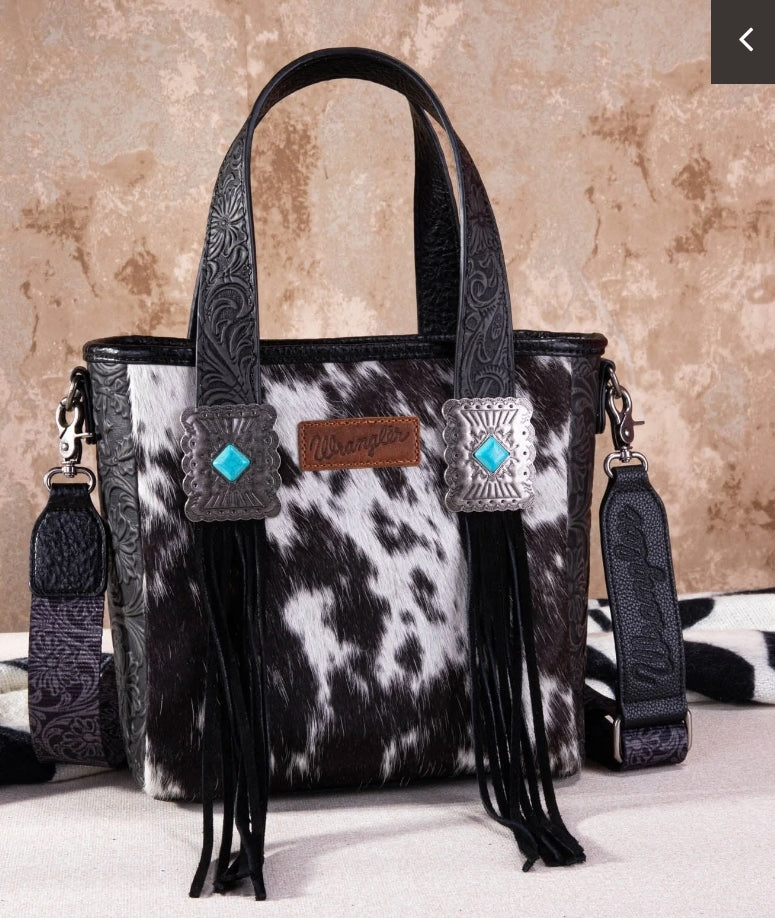 Concealed carry hair on hide bag by wrangler with fringe and turquoise accents on the handle. This has an additional strap and can be worn as a cross body.